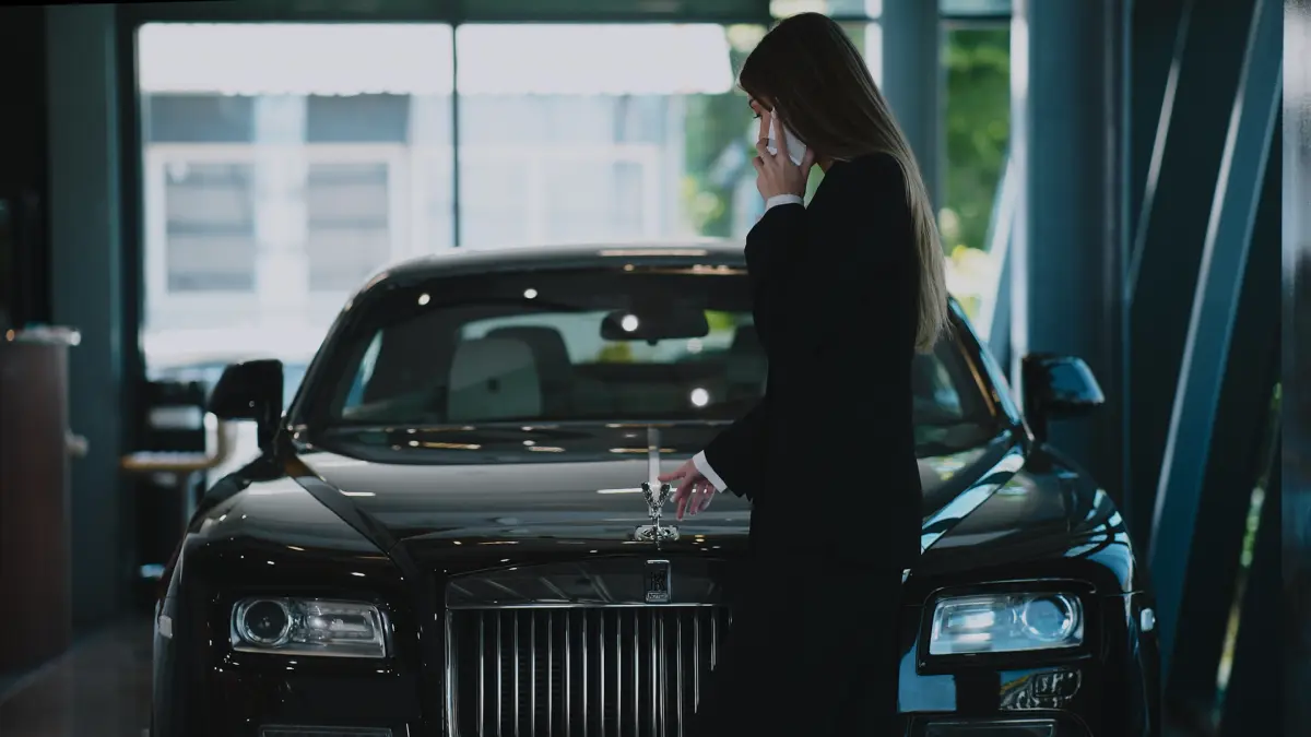 Consultantă lângă o mașină de lux, în showroom